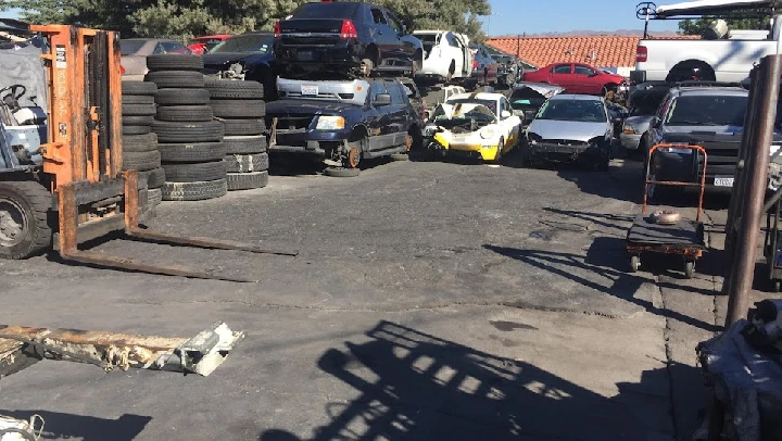 Auto wrecking yard with stacked tires and cars.