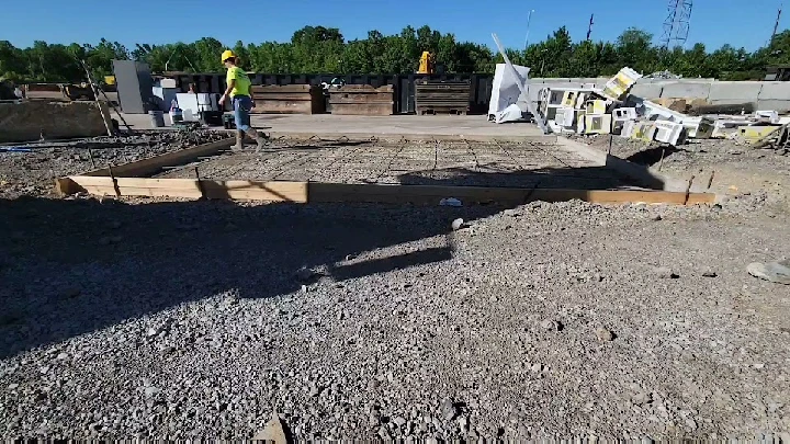 Construction site with rebar and workers pouring concrete.