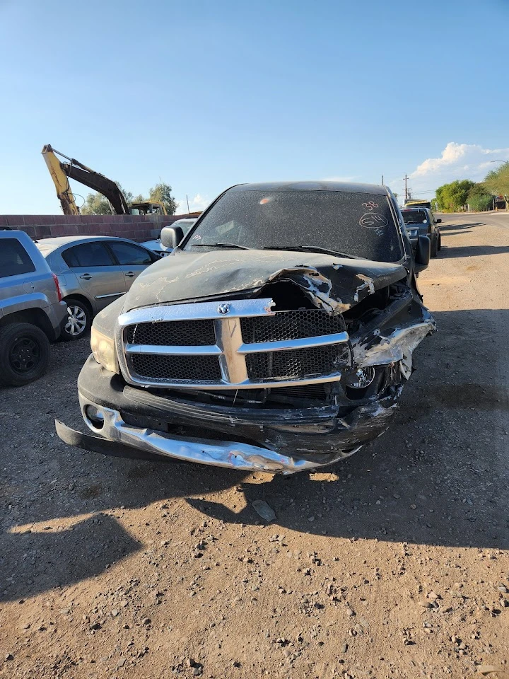 Damaged black SUV at A & G Auto Wrecking yard.