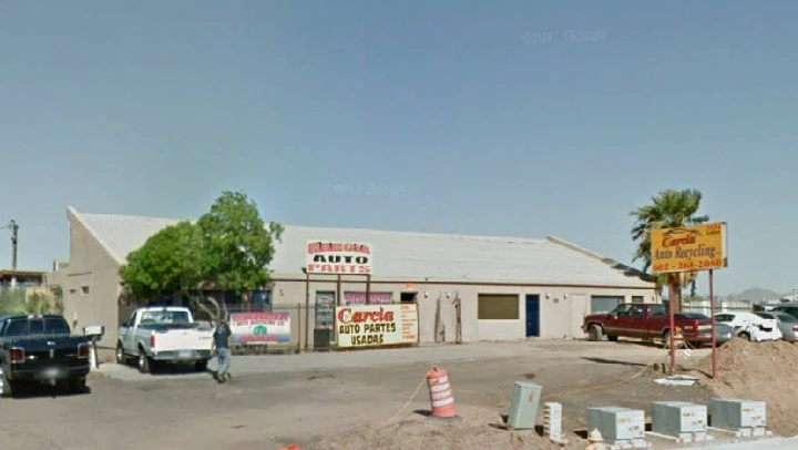 Garcia Auto Recycling building with signs and cars.