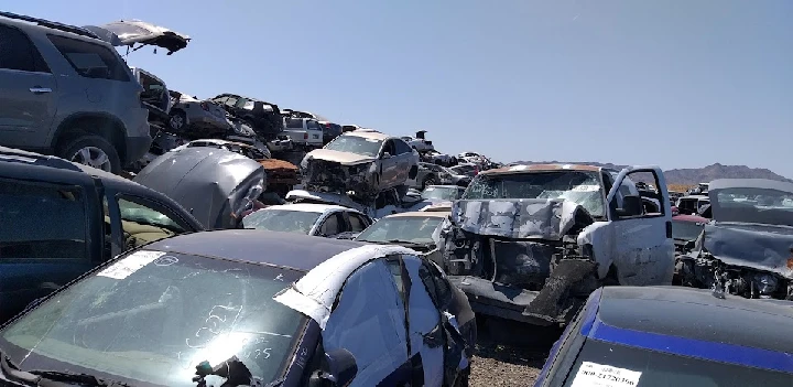 Junkyard filled with stacked, salvaged vehicles.