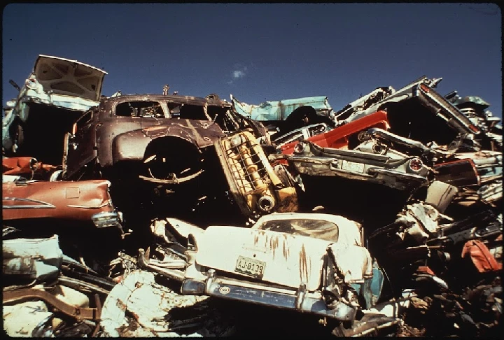 Junkyard pile of old, stacked cars and vehicles.