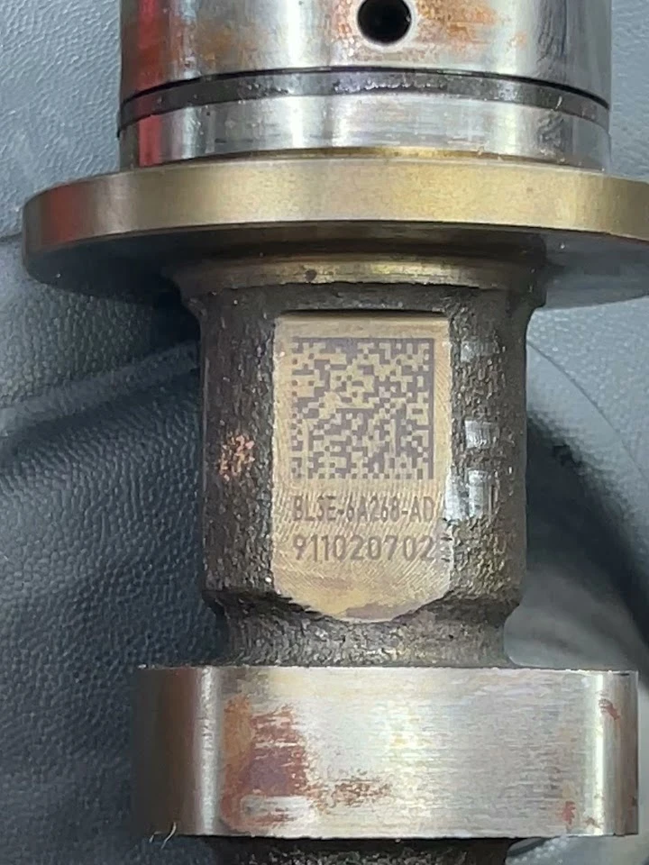 Metal component with QR code and serial number.