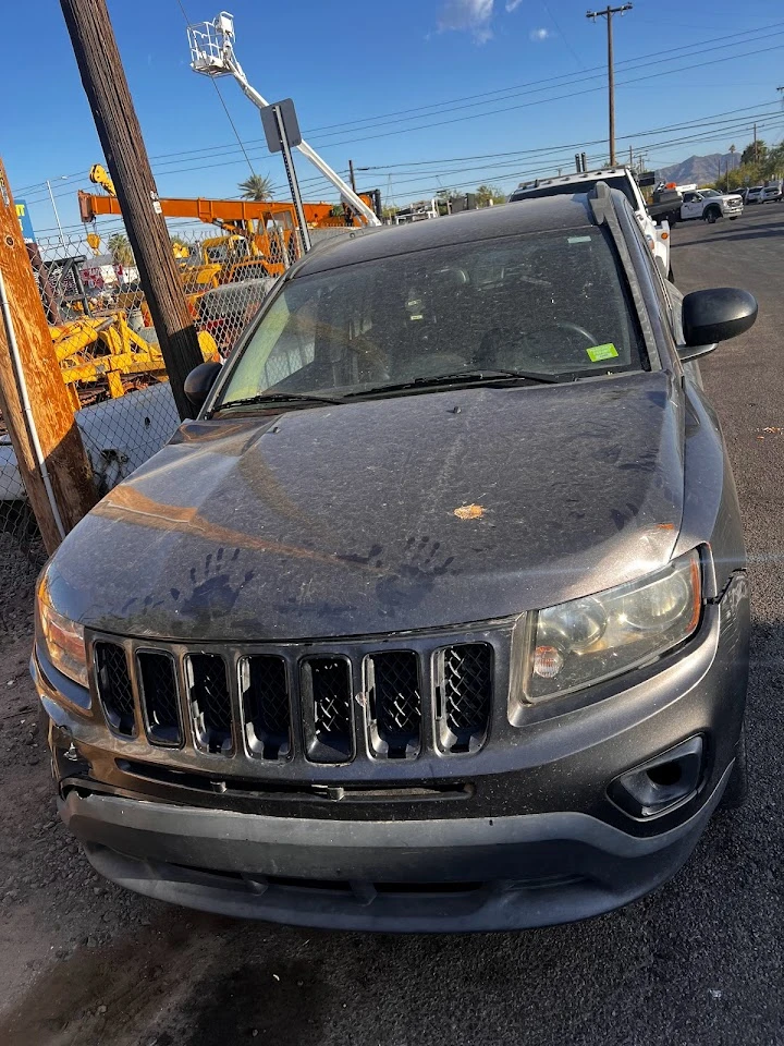 Old, dusty SUV at a junkyard.