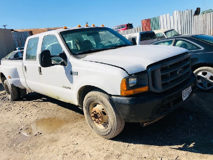 Old white truck at Ortiz Auto Parts lot.