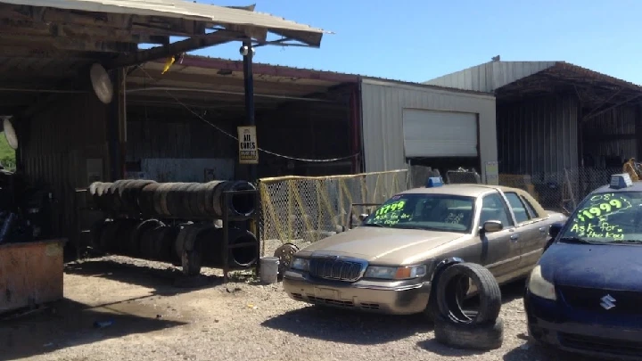 Pick-n-Pull vehicle yard with assorted cars and tires.