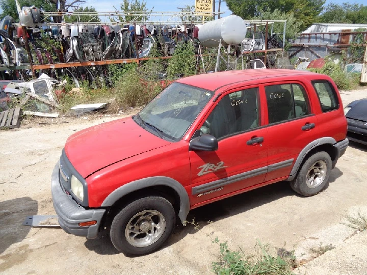 Red SUV parked at A Plus Auto Salvage yard.