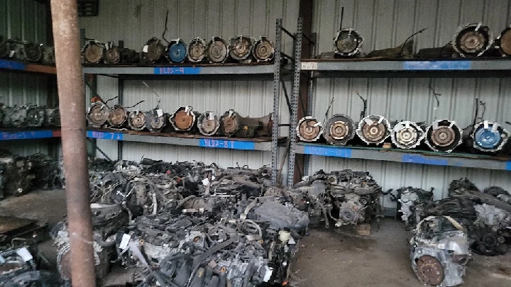 Salvaged car engines stored on shelves and floor.