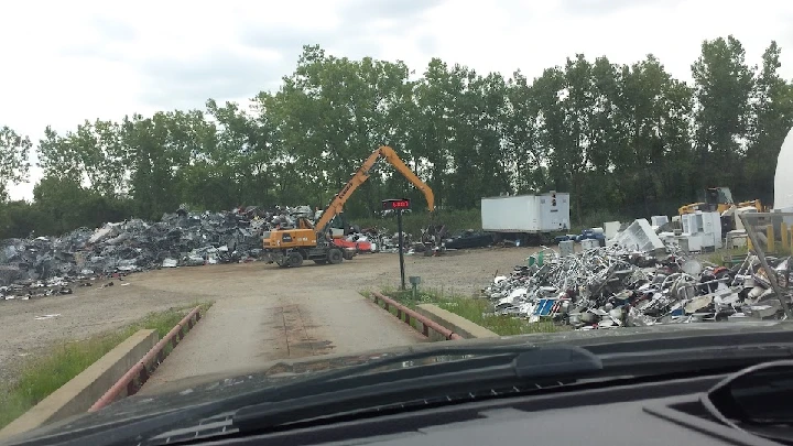 Scrap metal yard with machinery and piles of metal.