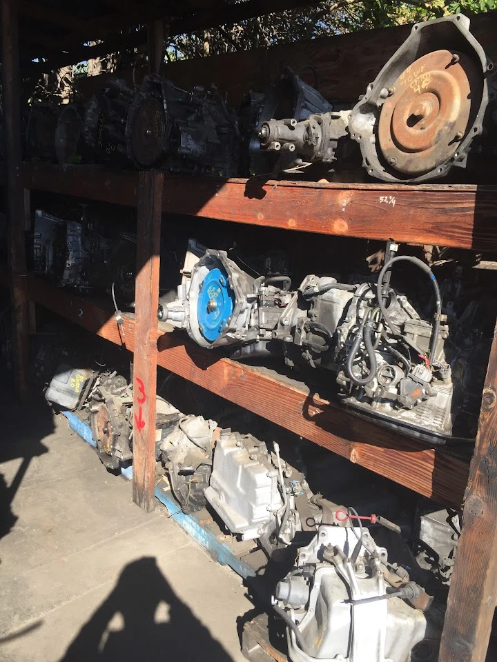 Stacked auto parts on wooden shelves at a wreckers.