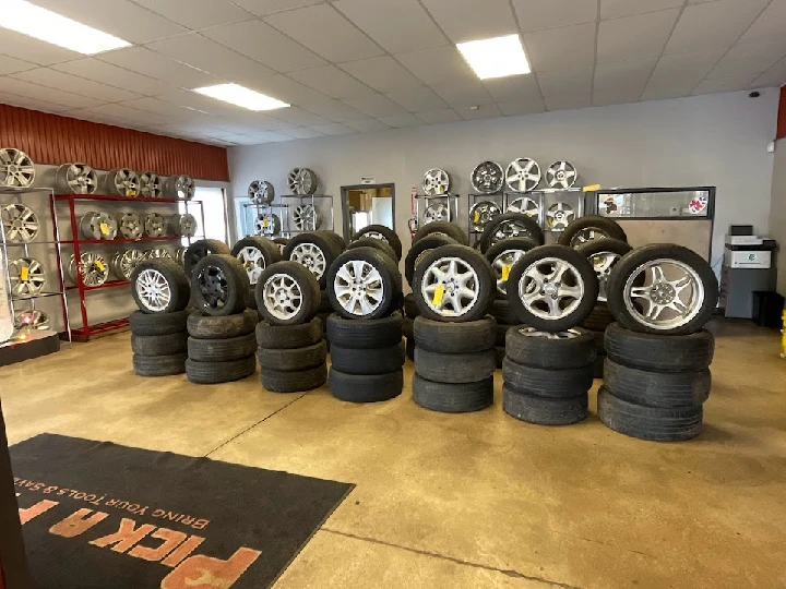 Stacked tires and wheels in a shop display.