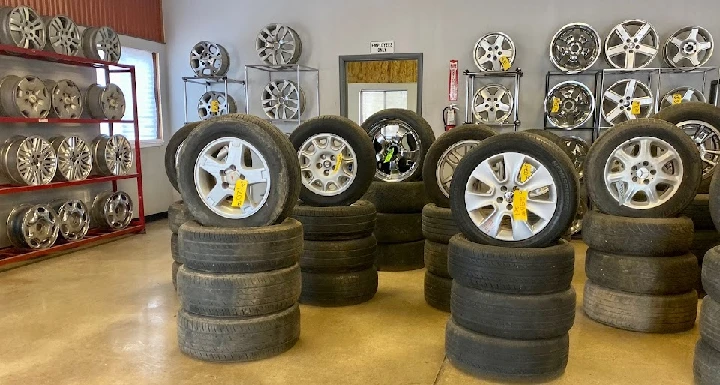 Tires and wheels stacked in a used parts shop.