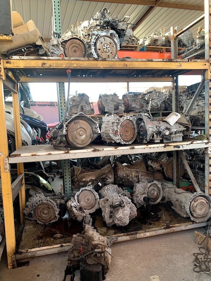 Used auto parts stacked on shelves at a junkyard.