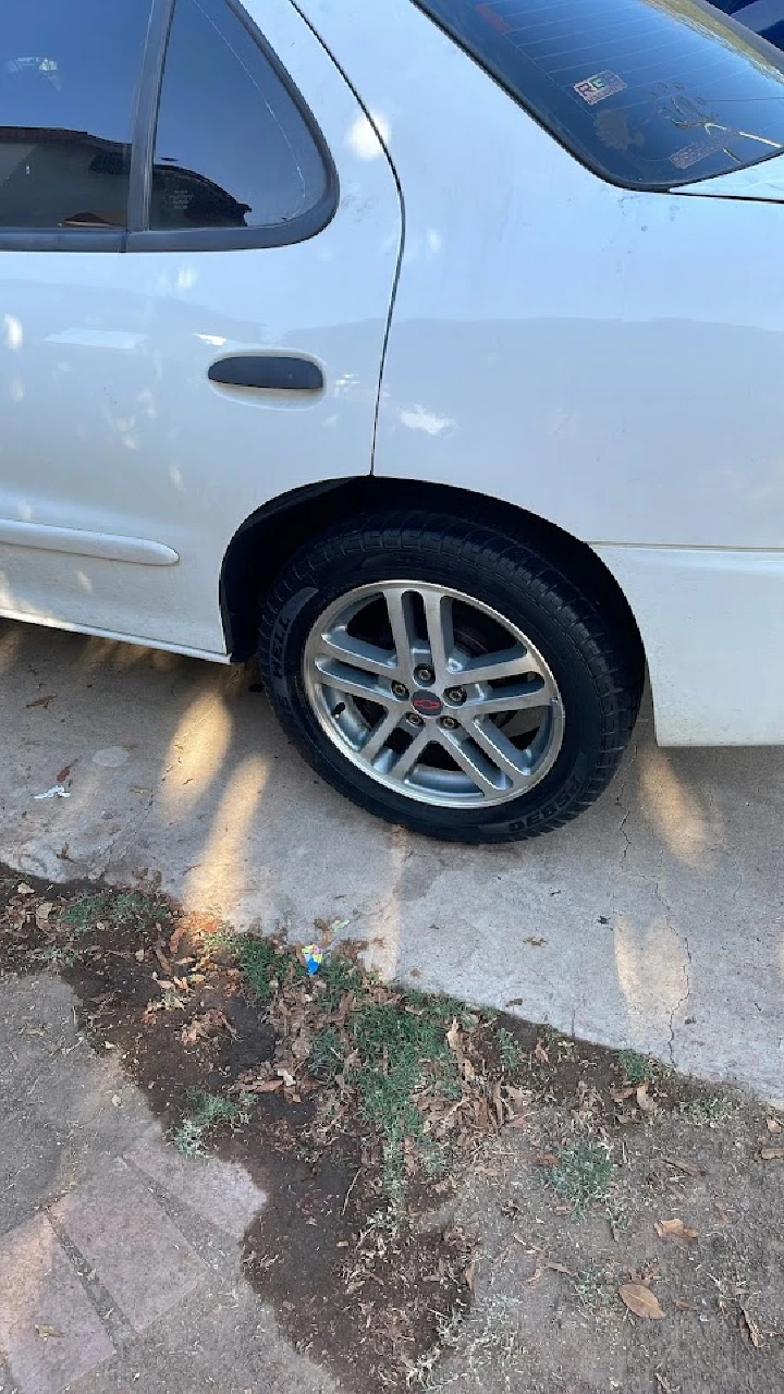 White car with alloy wheels parked on concrete.