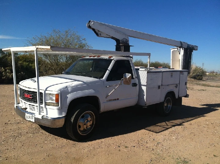 White GMC truck in desert landscape.