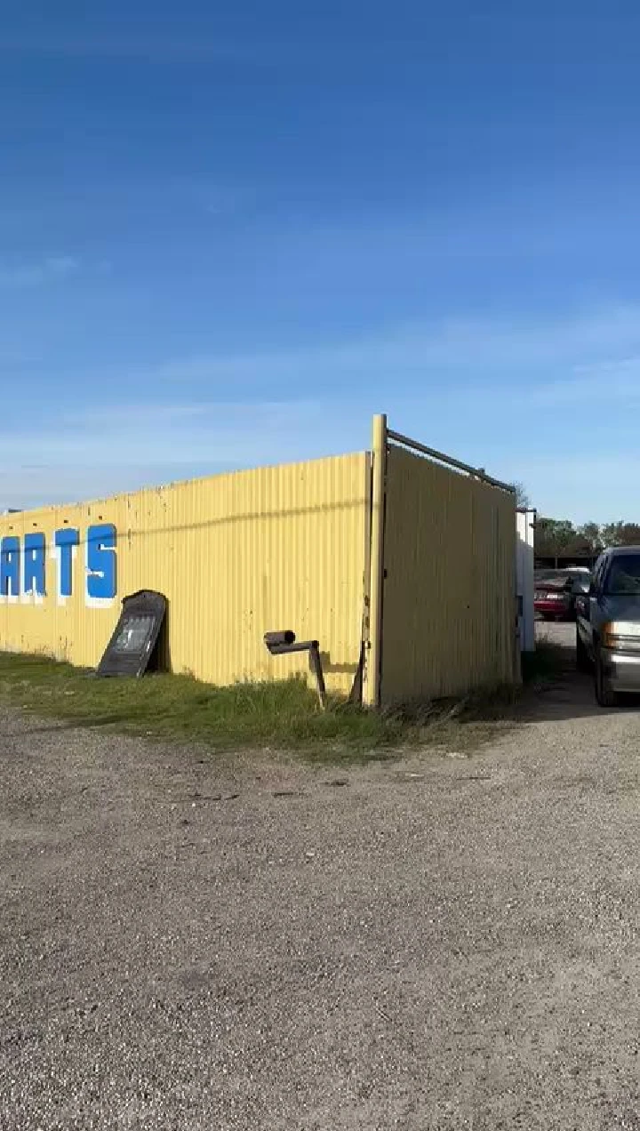 Yellow building with blue lettering and parked cars.