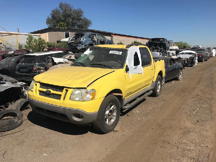 Yellow wrecked SUV in an auto salvage yard.