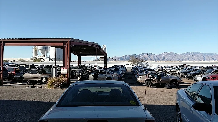 A spacious auto salvage yard with parked vehicles.