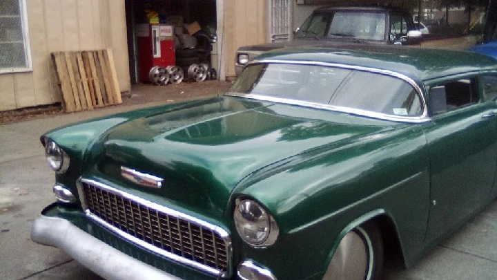 Classic green car with vintage styling outdoors.