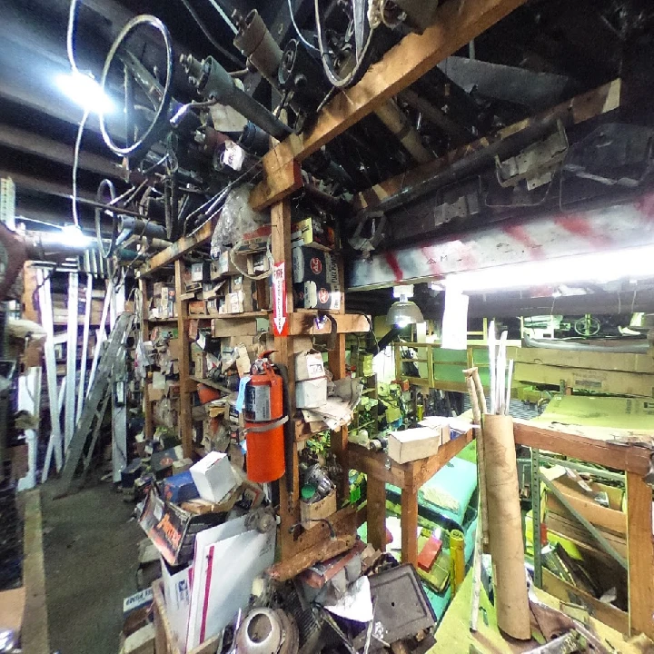 Cluttered workshop filled with old car parts.