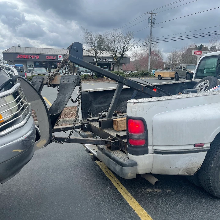 Tow truck connecting to a junk car for disposal.