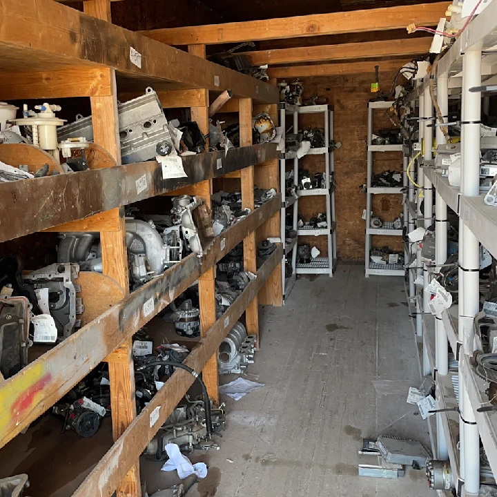 Used auto parts organized on shelves at a wrecking yard.