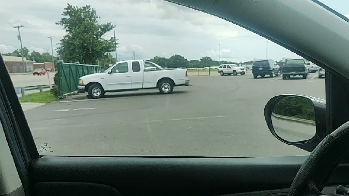 White pickup truck parked in a lot at U-Pull-It.