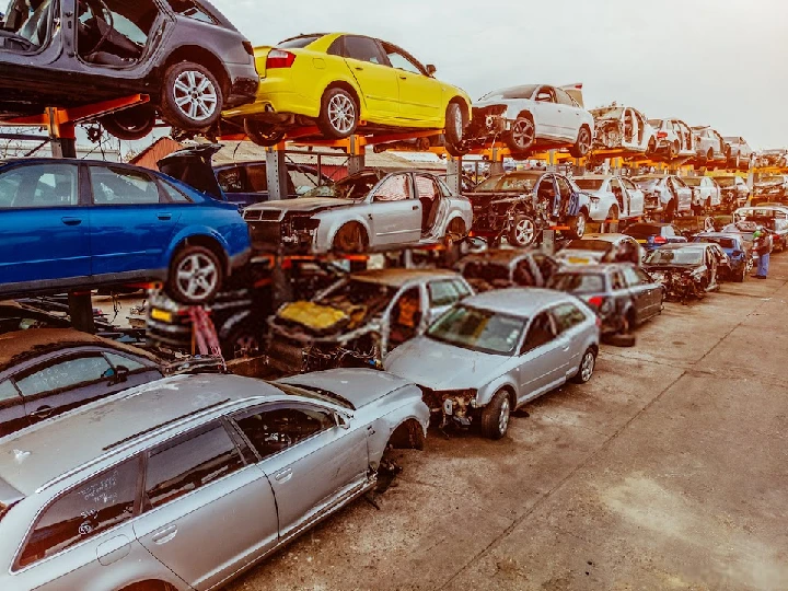 A car junkyard with stacked vehicles.