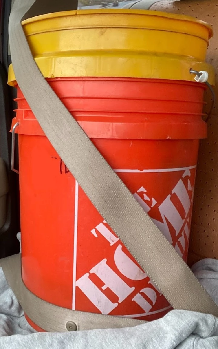 A secured bucket in a vehicle with a seatbelt.