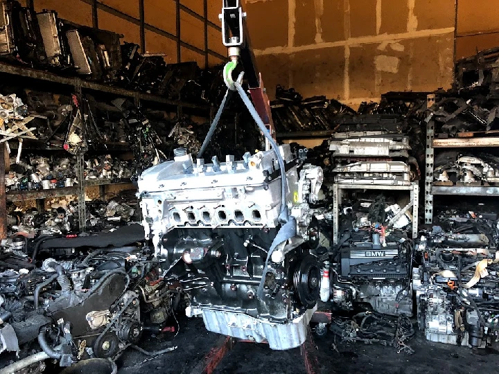 Auto parts and engines in a cluttered warehouse.