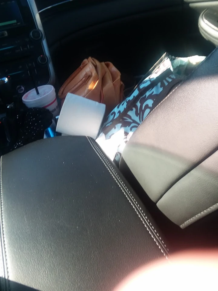 Auto parts inside a car, bags, and a drink cup.