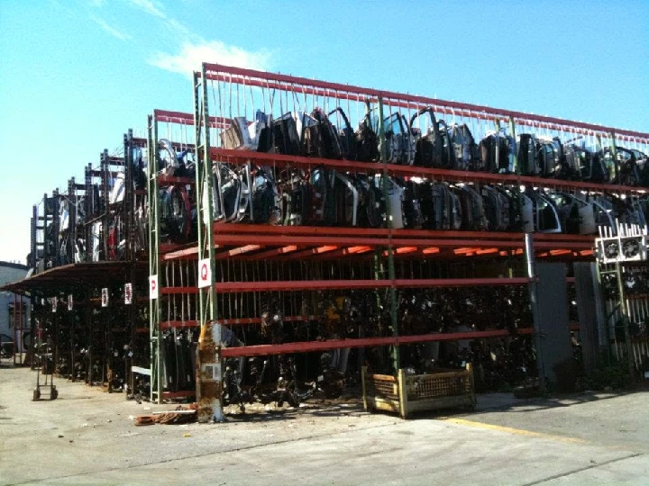 Auto salvage yard with stacked car parts and doors.