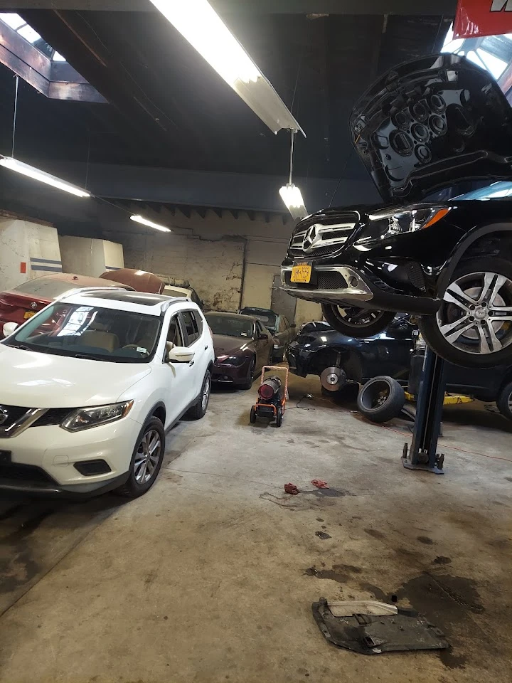 Auto shop interior with various vehicles and tools.