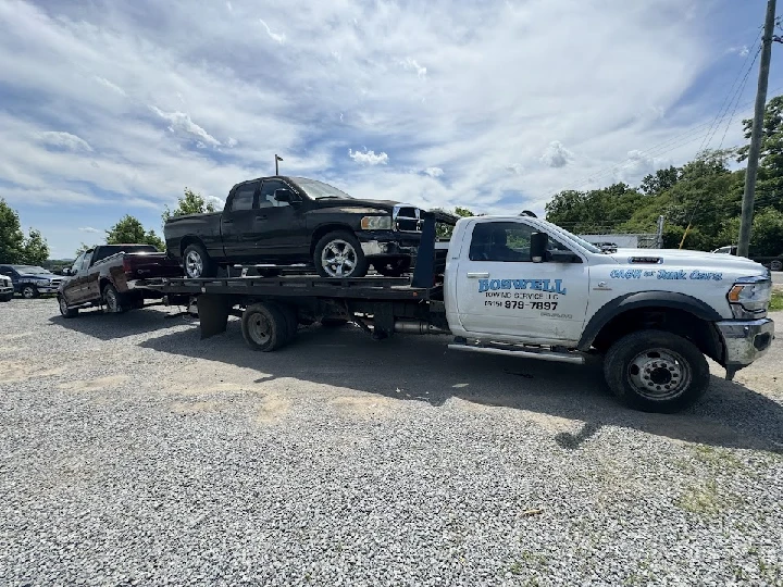 Boswell Towing truck with unwanted vehicles loaded.