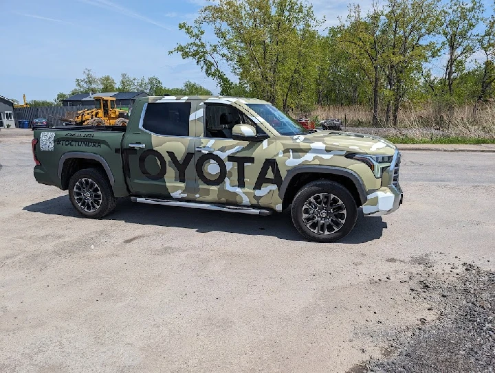 Camouflage Toyota Tundra parked outdoors.