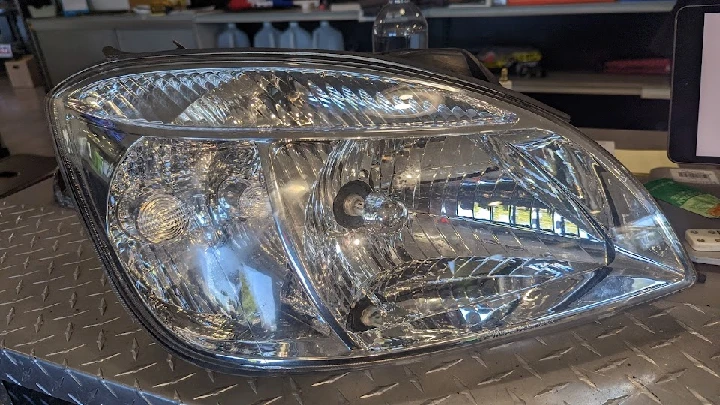 Car headlight displayed at Lucky's Self Serve Auto Parts.