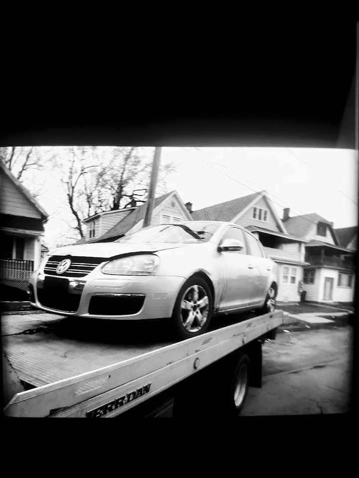 Car being loaded onto a truck in a residential area.