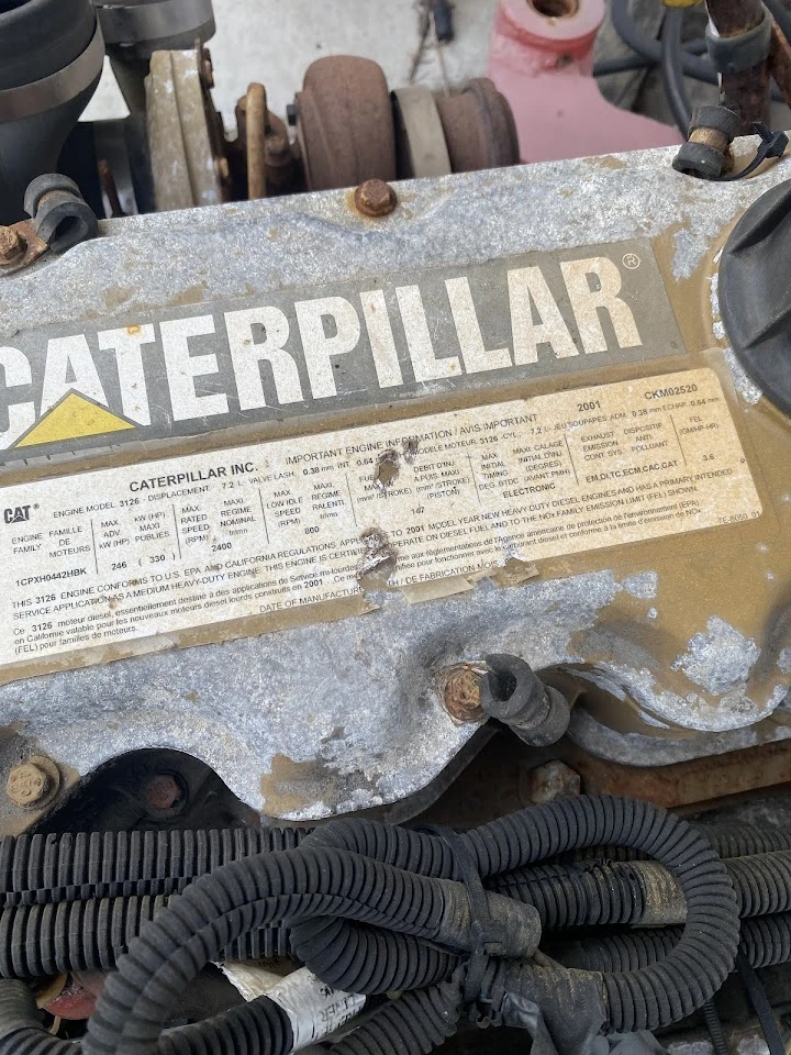 Caterpillar engine part with identification label.