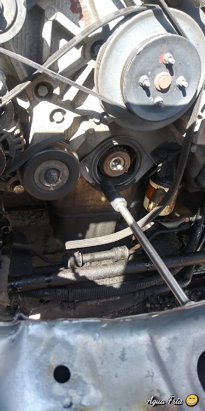 Close-up of a car engine with pulleys and belts.