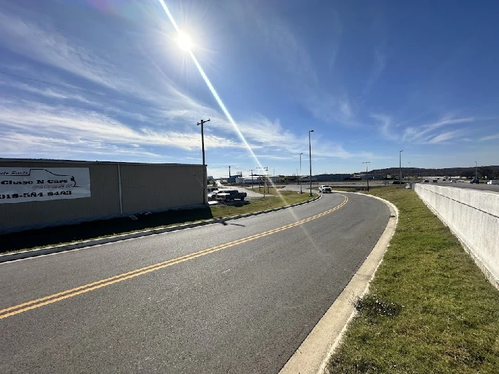 Curving road near 66 Auto Salvage under sunny skies.