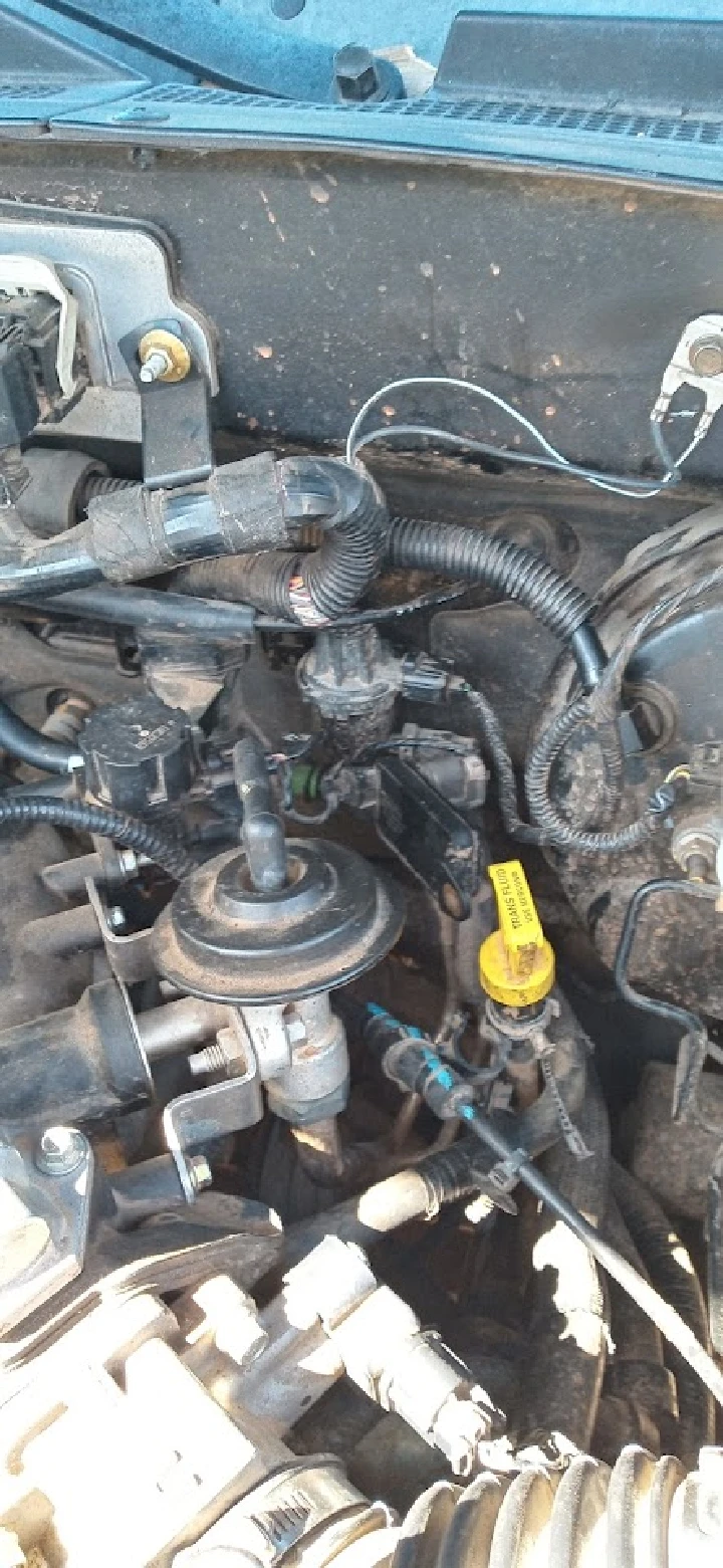 Engine components and wiring in an auto parts yard.