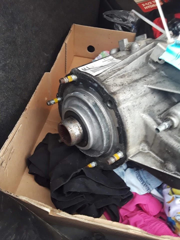 Engine part in a box with clothing scattered.