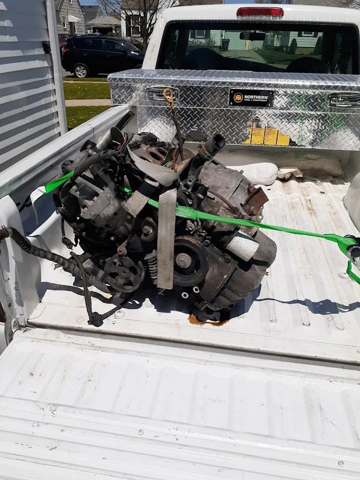 Engine secured in a truck bed with straps.