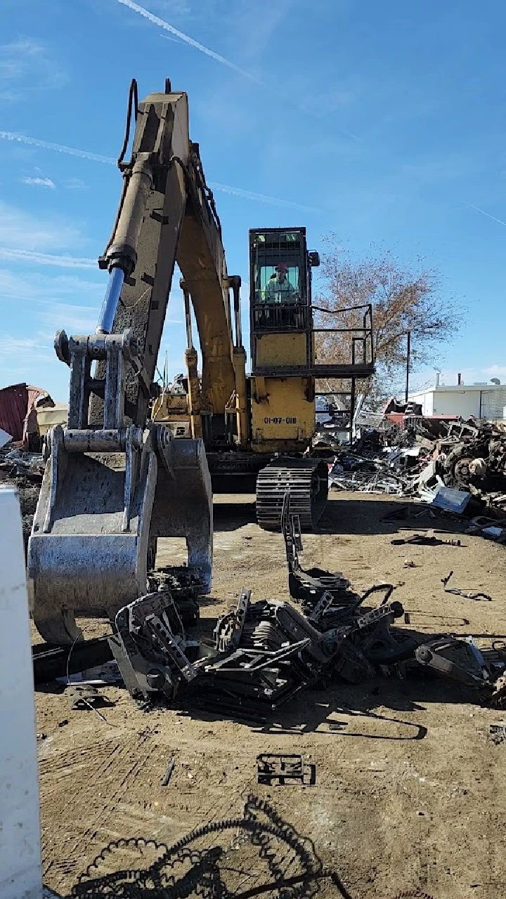 Excavator at a recycling facility with scrap metal.