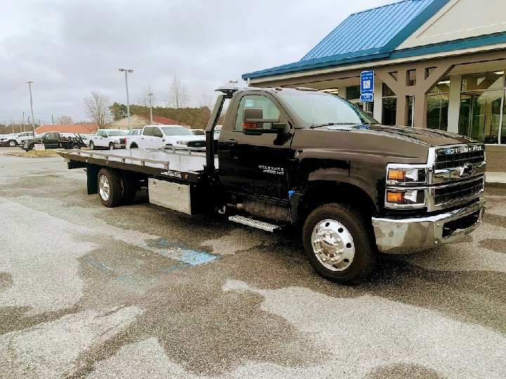 Heavy-duty tow truck parked outside a business.