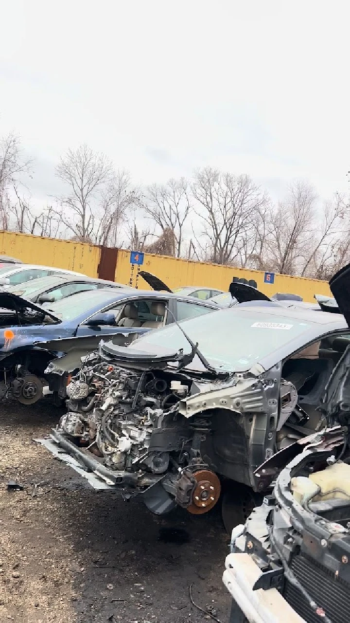 Junkyard with disassembled cars and machinery.