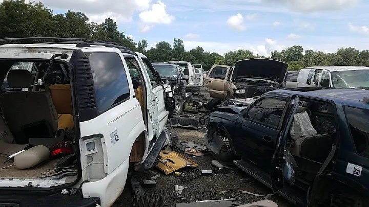 Junkyard scene with dismantled vehicles and parts.