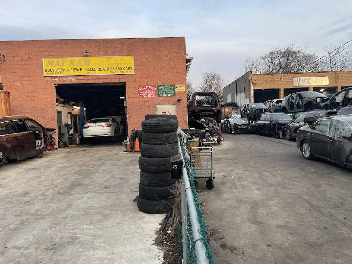 May Kam Auto Center with vehicles and tires outside.