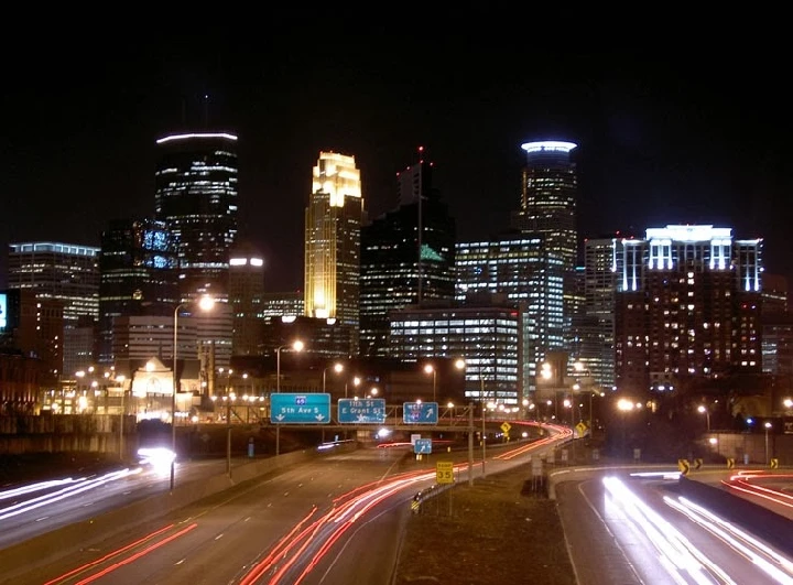 Minneapolis skyline at night with traffic below.