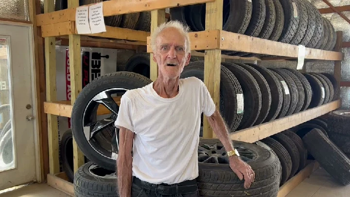 Person in a tire shop surrounded by tires.